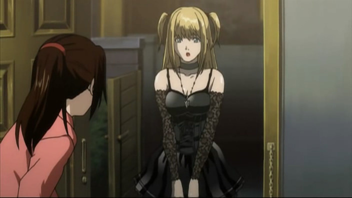 Misa in a black dress with a corset design, lace arm warmers, chunky necklace, and choker